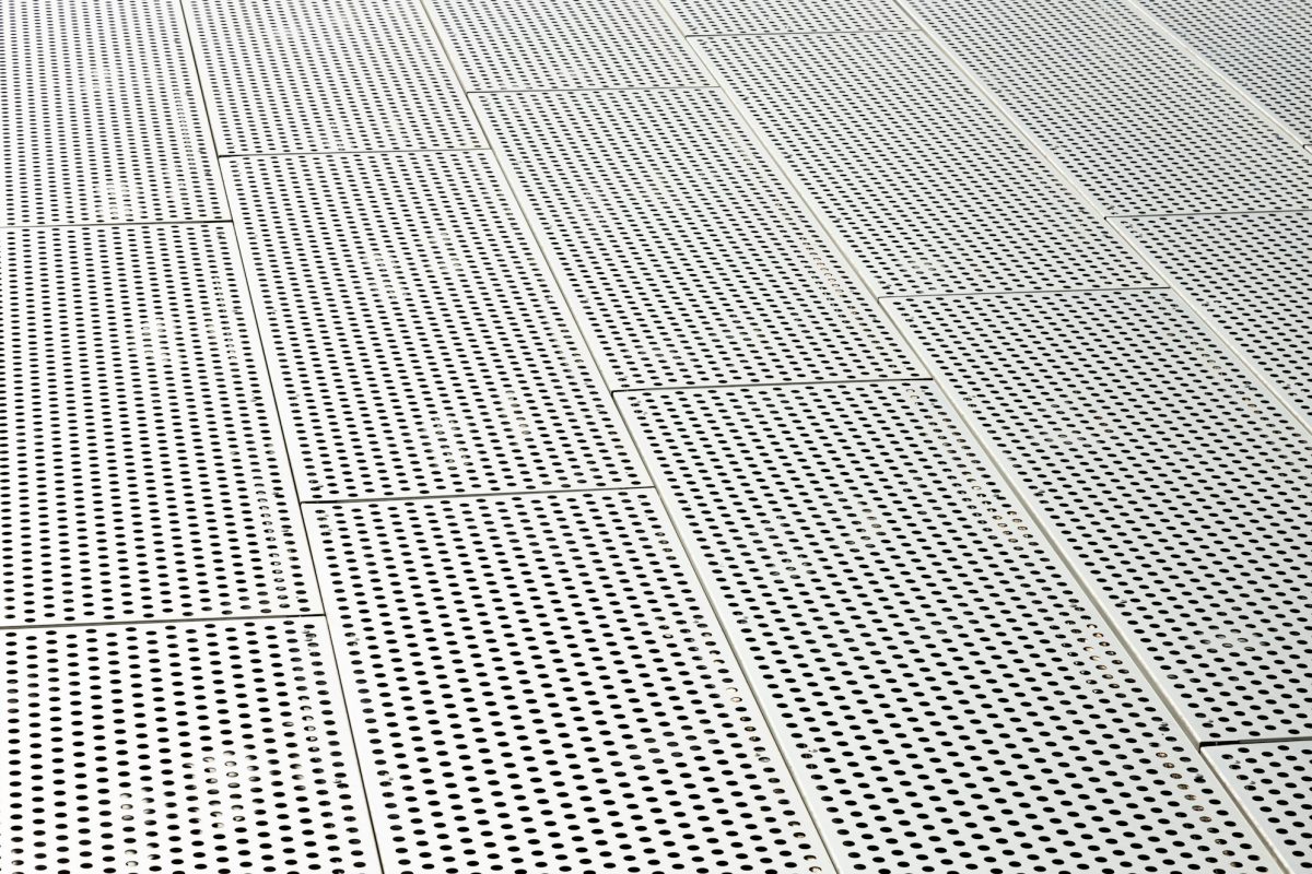 Diagonal view of metall grilles and round holes in metal surface, perforated panels